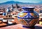 a colorful vase on a ledge overlooking a city