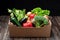Colorful vegetable basket and filled with broccoli, lettuce, aubergines, onions, zucchini, peppers and potatoes. On a