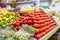 Colorful vegetable and fruit stand with tomatoes, grapes, mangoes, and more