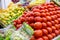 Colorful vegetable and fruit stand with tomatoes, grapes, mangoes, and more