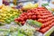 Colorful vegetable and fruit stand with tomatoes, grapes, mangoes, and more