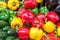 Colorful vegetables background on a market. Yellow, green and red bell peppers, zucchinis and eggplants, summer vegetable