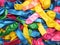 Colorful vibrant background of a pile of deflated party balloons in the colors of the rainbow or spectrum for a festive occasion o