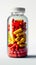 Colorful vitamins in clear bottle, red and yellow capsules enclosed