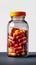 Colorful vitamins in clear bottle, red and yellow capsules enclosed