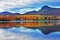 Colorful VT Autumn reflection ablaze surrounded by drearie hills HDR