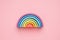 Colorful Waldorf wooden rainbow in a montessori teaching pedagogy on pink background