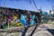 A colorful wall mural of a red robot in Little Five Points on the side of a black building with a gorgeous clear blue sky