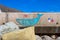 A colorful wall mural of a whale on the side of a highway at the beach surrounded by rocks with blue sky at Rincon Beach