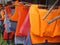 Colorful water life vest. Life jackets hanging on clothes line. Buoyancy jackets on a rail. Water sports safety accessory. Sports