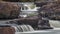 Colorful Waterfall rocky quarry surrounded by green tries and painted rocks