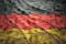 Colorful waving german flag on a dollar money background