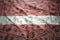 Colorful waving latvian flag on a dollar money background
