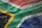 Colorful waving national flag of south africa on a american dollar money background.