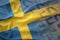 Colorful waving national flag of sweden on a euro money banknotes background.