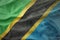 Colorful waving national flag of tanzania on a american dollar money background.