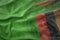 Colorful waving national flag of zambia on a american dollar money background.