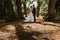 Colorful wedding bouquet lying on path in park with wedding couple in background