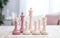 colorful white and pink chess on chessboard on white wooden table competition concept soft light