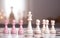 colorful white and pink chess on chessboard on white wooden table competition concept soft light