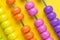 Colorful wooden pink and orange abacus beads on yellow background, business financial or accounting profit and loss concept, or u