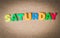 Colorful wooden word SATURDAY on Cork board with selective focus