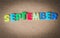 Colorful wooden word SEPTEMBER on cork board with selective focus