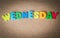Colorful wooden word WEDNESDAY on Cork board with selective focus