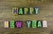 The colorful word `Happy New Year` over the wooden board.