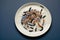 Colorful worms on a white plate, isolated on blue background