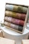 Colorful yarn on spool, yarn on tube, cotton, wool, linen thread on wooden shelf