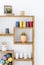 Colorful yarns and plants on wooden shelves in white interior. Real photo