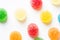 Colorful yellow red orange green gummy jelly candies coated with sugar arranged in pattern on white background. Kids birthday