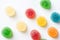 Colorful yellow red orange green gummy jelly candies coated with sugar on white background. Kids birthday party Halloween sweets