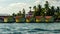 Colorful yellow waterfront cabins nestling amongst tropical palm trees at a resort on Bocas Del Toro Panama viewed across the