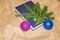 Colorfull Christmas ball, branch of spruce tree and blue book on gray table. Happy New Year decoration