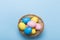 Colorfull easter eggs in nest on blue color background with space