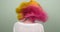 Coloring hair, teenage girl waving bright dyed colored pink yellow hair, back view