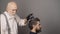 Coloring man hair process. Professional hairdresser dying hair of bearded man in barber shop.