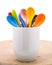 Colors ceramics spoon in mug on wooden backdrops. Colorful concept