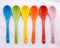 Colors ceramics spoon on white fabric background. Colorful concept