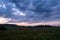 The colors of the sky after sunset with clouds above the mountain meadow