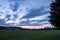 The colors of the sky after sunset with clouds above the mountain meadow