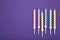 Coloruful birthday candles on violet background. Birthday celebration. Vertical photo