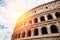 Colosseum or Coliseum ancient ruins background blue sky Rome, Italy, stone arches and sunset