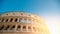 Colosseum or Coliseum ancient ruins background blue sky Rome, Italy, view from below, stone arches and sunrays