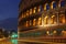 Colosseum at night with colorful blurred traffic lights