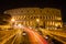 Colosseum at night with colorful blurred traffic lights