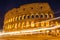 Colosseum at night with colorful blurred traffic lights