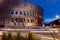 The Colosseum in Rome, Italy at night with traffic streaking pas